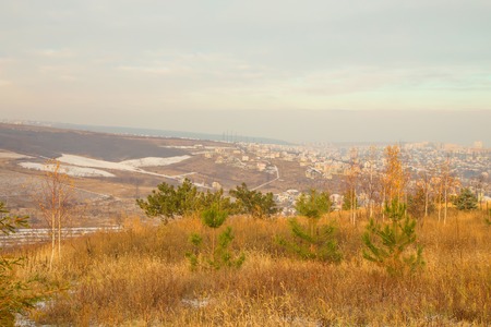 Early snow on the plowed ground and roads. A late autumn panoramic view from a hillの写真素材