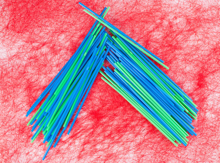 Plastic various drinking straws. Located on a red background.