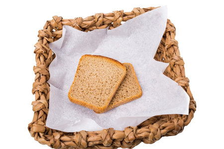 Wicker basket with roasted rye toasts. Isolated on a white background.