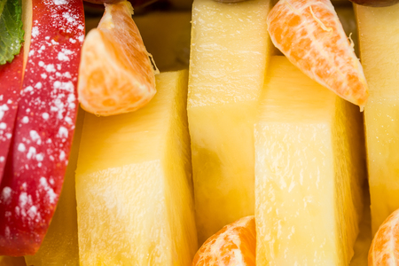 Sliced orange and pineapple on a fruit platter. Macro. Can be used as a  whole background.の写真素材