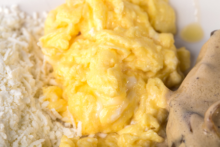 Scrambled eggs with grated cheese and pork meat covered with mushroom sauce. Macro. Photo can be used as a whole background.の写真素材