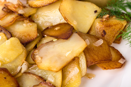 Delicious roasted potatoes with minced onion and fresh dill. Macro. Can be used as a whole background.の写真素材