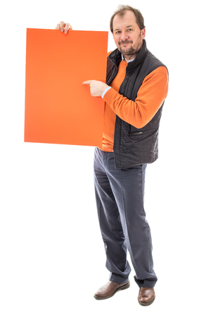 Man holding sheet of orange cardboard and point the finger on him. Front view. Isolated on a white background.の写真素材