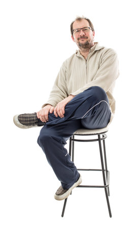 Confident male model with crossed legs on chair. Isolated on a white background.