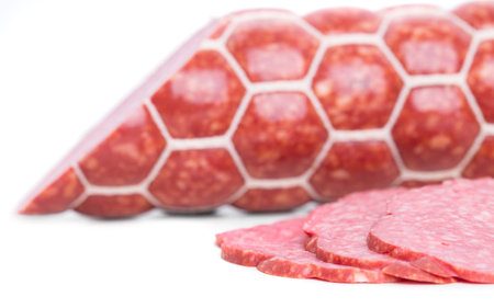Delicious italian salami sausage in natural casing. Macro. Isolated on a white background.の写真素材