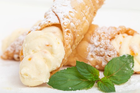 Waffle rolls with delicious whipped apricot cream and fresh mint. Macro. Photo can be used as a whole background.の写真素材