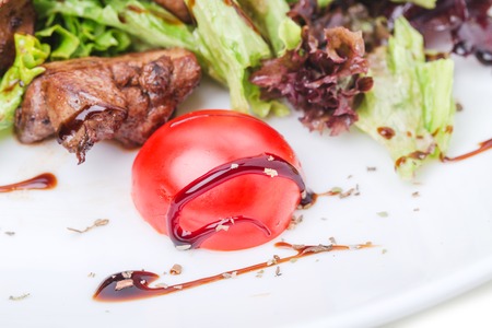 Grilled veal shish kebab with red onions covered with soya sauce on fresh lettuce leaves and tomatoes cherry. Macro. Photo can be used as a whole background.の写真素材
