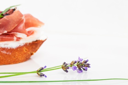 Prosciutto bruschetta with ricotta and arugula covered with caramelized balsamic vinegar. Macro. Photo can be used as a whole background.の写真素材