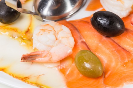 Delicious smoked salmon fish platter garnished with shrimps and olives. Macro. Photo can be used as a whole background.の写真素材