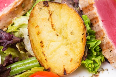 Classic nicoise salad with roasted potatoes and grilled tuna. Macro. Photo can be used as a whole background.の写真素材