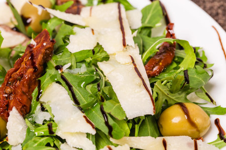 Fresh arugula with grated parmesan covered with balsamic vinegar. Macro. Photo can be used as a...