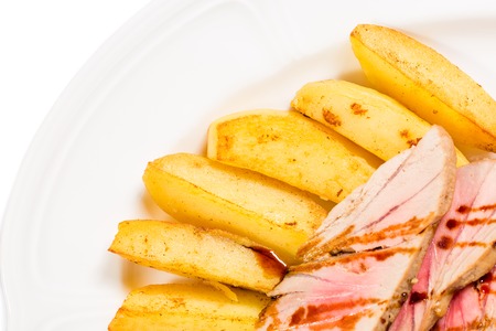 Baked potato wedges and grilled tuna fillet. Macro. Photo can be used as a whole background.の写真素材