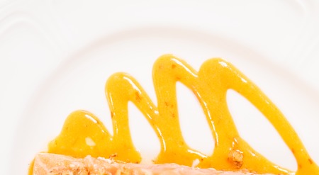 closeup of apricot mousse on the plate for baked salmon fillet. Macro. Photo can be used as a whole background.の写真素材