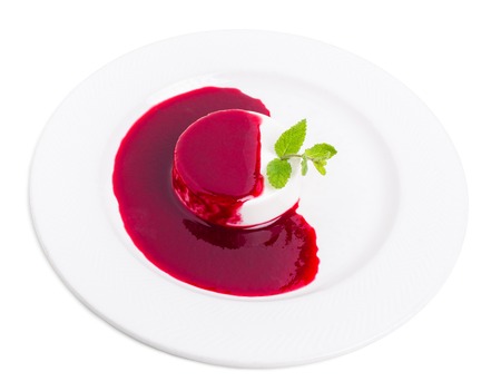 Delicious vanilla panna cotta with raspberry jam and fresh mint. Isolated on a white background.の写真素材