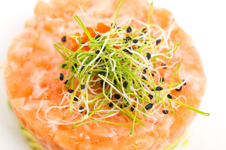 Salmon tartare with fresh sprouts and red caviar on top. Macro. Photo can be used as a whole backgroundの写真素材