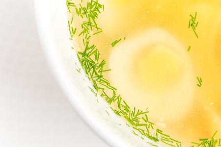 Chicken consomme soup with homemade noodles and quail eggs. Macro. Photo can be used as a whole background.の写真素材