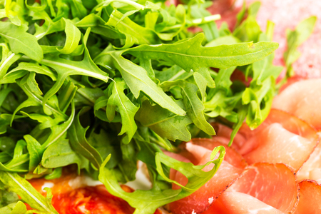 Delicious italian dried meat with heap of arugula. Macro. Photo can be used as a whole background.の写真素材