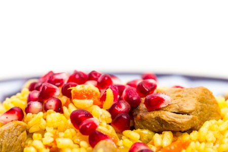 Fragrant pilaf with lamb meat and dried apricots. Covered with fresh pomegranate seeds. Macro. Photo can be used as a whole background.の写真素材