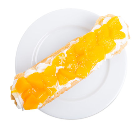 Classic eclair filled with custard and canned peaches. Isolated on a white background.
