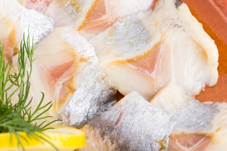 Sliced herring and dill on plate. Part of fish platter closeup. Macro. Photo can be used as a whole background.の写真素材