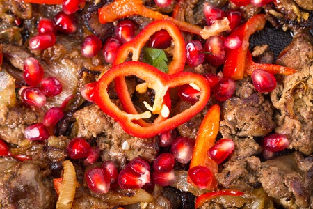 Stewed chicken livers with paprika and pomegranate seeds. Macro. Photo can be used as a whole background.の写真素材