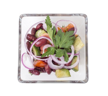 Vegetable salad with red beans in a square glass bowl.  Isolated on a white background.の写真素材