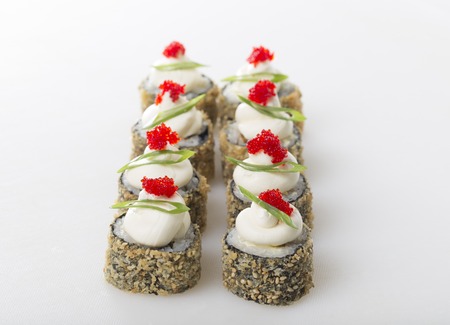 Crispy sushi roll with tobiko caviar and japanese mayonnaise on top. On a table as a background.の写真素材