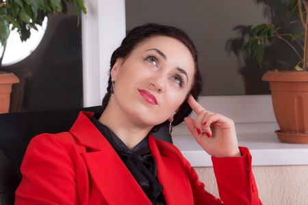 Business woman sitting at the office with a pensive look. Photo can be used as a whole background.の写真素材