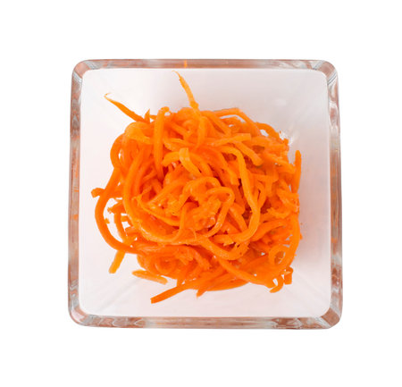 Spicy Korean carrot salad in a square glass bowl.   Isolated on a white background.の写真素材