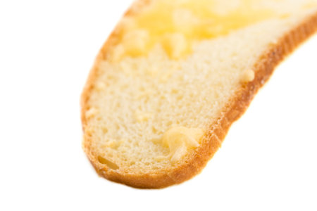 Slice of bread with melted cheese closeup. Isolated on a white background.