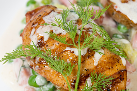 Grilled chicken fillets with bacon and peas covered with delicious white sauce. Macro. Photo can be used as a whole background.の写真素材