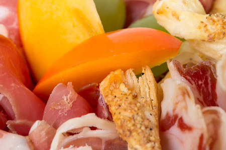 Mixed italian dried meats platter with mango. Macro. Photo can be used as a whole background.の写真素材