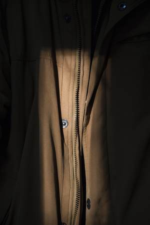 Zipper fragment jacket. Brown coat hanging in the sun.の写真素材