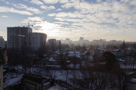 Winter in the city. Snow on roofs and the blue sky with clouds.の写真素材