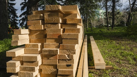 Piled comstruction boards. It is storaging on outdoors.の写真素材