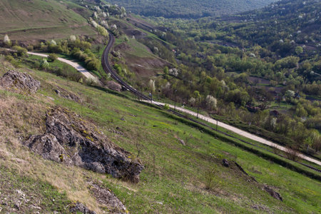 Railway in the hills. Cliffs and village, and forest on the background.