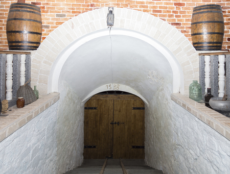 Main entrance to an old moldavian cellar. In image are located white walls and a wooden gate.の写真素材