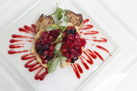 Fried meat and pancakes with sweet fruit jam. This is located on a white plate. Close-up.の写真素材