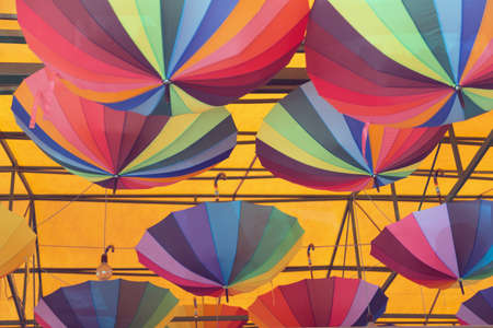 Rainbow umbrellas under the roof as part of the interior. This image may be used as a background. Close-up.の写真素材