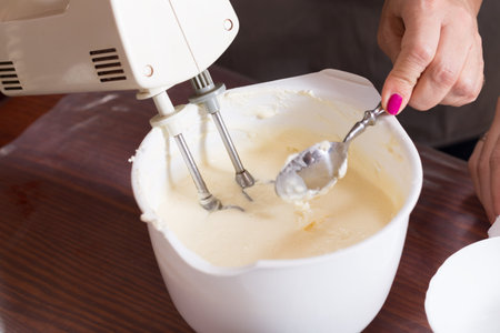 Whipping the cream with an electric mixer. Close-up.