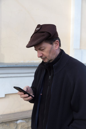 Middle-aged man with a smartphone in the street. Close-up.