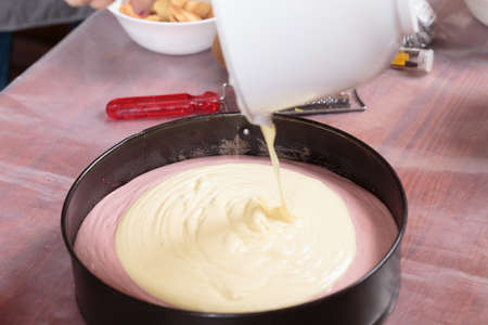 Putting the cream into a baking dish. Close-up.の写真素材