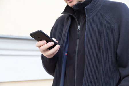 Middle-aged man with a smartphone in the street. Close-up.