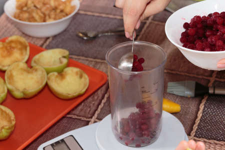 Weighing frozen cranberries to make jelly. Close-up.の写真素材