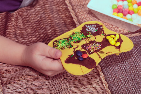 Decorating chocolate with various sprinkles. Close-up.