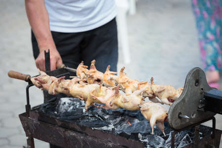 Quail barbecue on skewers on a grill brazier. Close-up.の写真素材