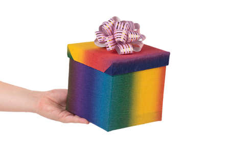 Colorful gift box with golden bow in hand. Isolated over white background. Close-up.の写真素材