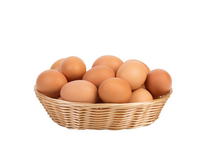 Fresh eggs in a wicker basket. Isolated over white background. Close-up.の写真素材