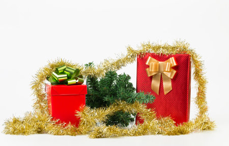 Two red boxes with bows and Christmas tree. Isolated over white background. Close-up.の写真素材