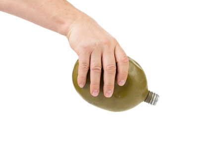 Military metal flask in a hand. Isolated on a white background. Close-up.の写真素材